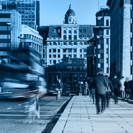Busy street with moving cars and people walking.