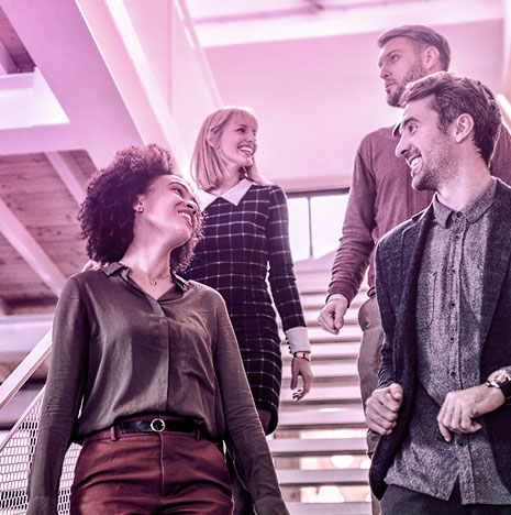 Group of young adults chatting and walking down stairs.