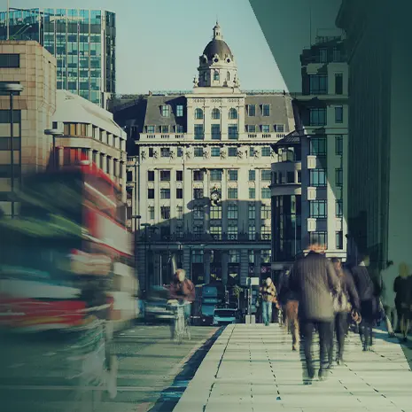 Busy street with moving cars and people walking.
